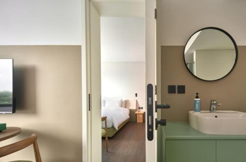 a bathroom with a sink and a mirror at Go Hotel Nakhon Sawan in Ban Pak Nam Pho