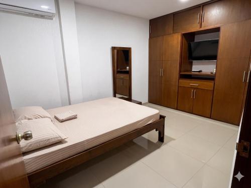 a bedroom with a bed and a tv and cabinets at Casa del Prado in Cali