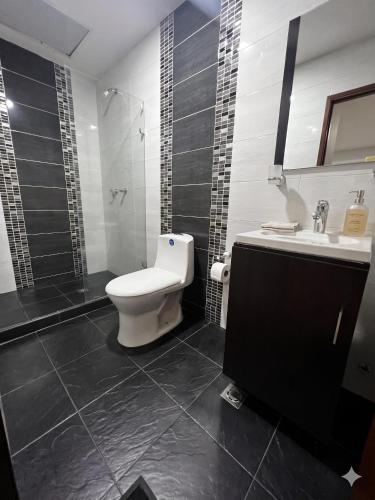 a bathroom with a toilet and a sink at Casa del Prado in Cali