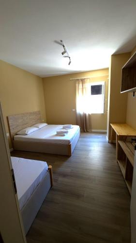 a hotel room with two beds and a window at Kron Apart Hotel Golem in Golem