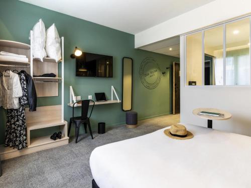 a bedroom with a white bed and a desk at ibis Styles Limoges Centre in Limoges