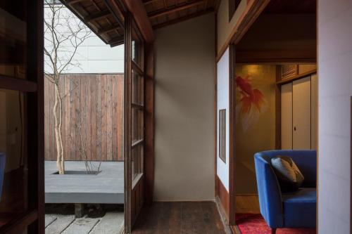 a hallway with a blue chair and a window at Hikoso-machi Kin no Ma in Kanazawa