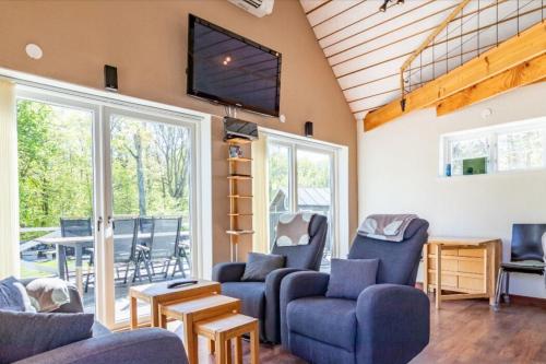 a living room with blue chairs and a tv at The Aspö Hideaway in Drottningskär