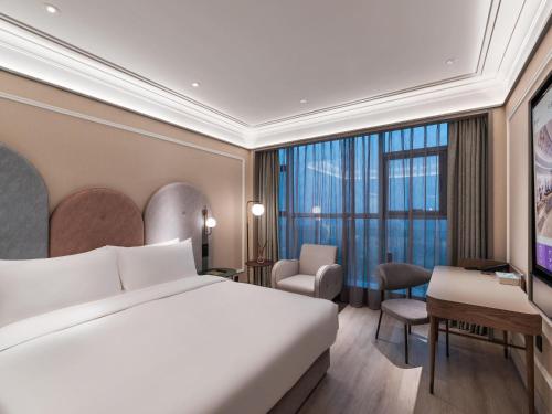 a hotel room with a bed and a desk at Mercure Hangzhou Qingchun in Hangzhou