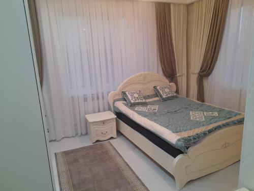 a small bedroom with a bed and a window at Guest House Maral in Bokonbayevo