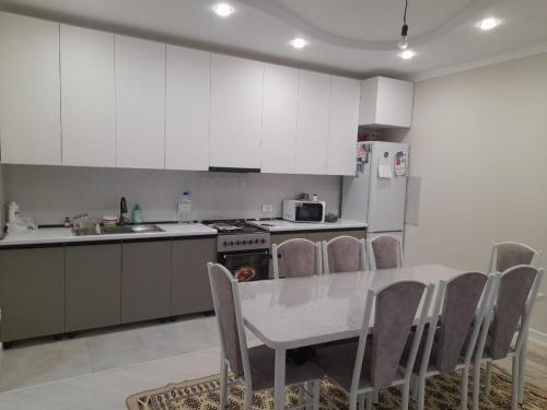 a kitchen with a table and chairs and a refrigerator at Guest House Maral in Bokonbayevo