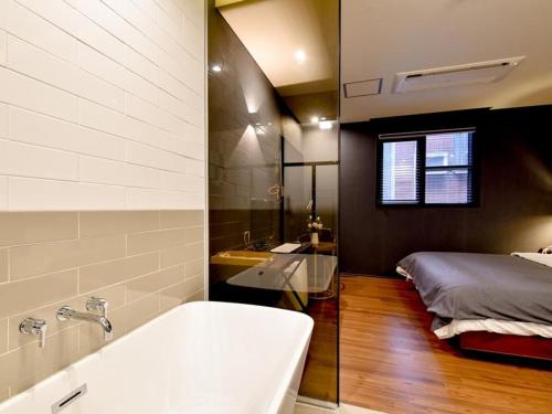 a bathroom with a bath tub and a bed at Brown Dot Yangjeong in Busan