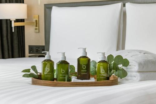 a tray with three bottles of soap on a bed at Hotel Nikko Kaohsiung in Kaohsiung