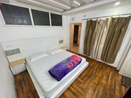 a small bedroom with a bed in a room at Tatva stays in Dharmsāla