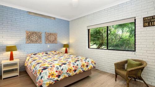 a bedroom with a bed and a chair and a window at The Cove in Scotts Head