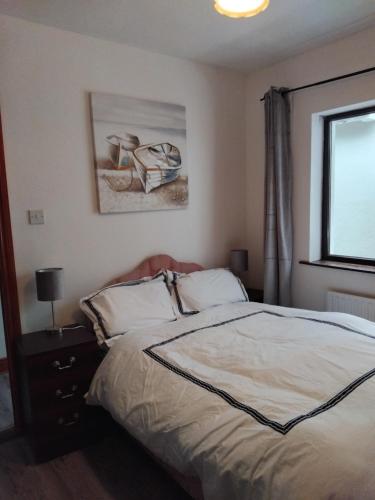 a bedroom with a bed and a window at Teach Caitlin in Ballina