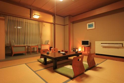 a living room with a table and chairs at Eshin no Sato Yasuragisou in Joetsu