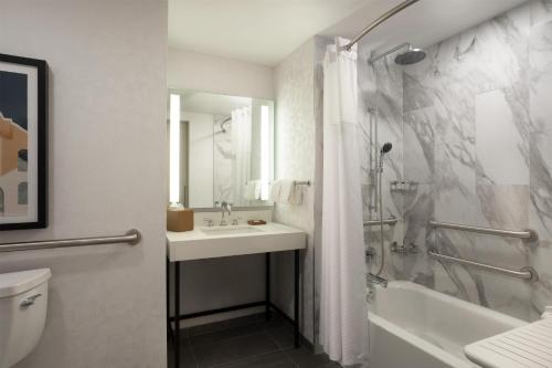 a bathroom with a sink and a shower and a toilet at Hyatt Regency San Antonio Riverwalk in San Antonio