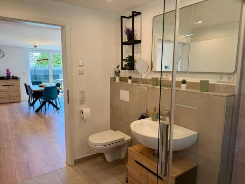 a bathroom with a sink and a toilet and a table at Ferienwohnung zum Buchfeld in Windesheim