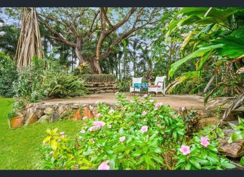 a garden with a bench and some pink flowers at Enchanted Garden Escape in Mowbray