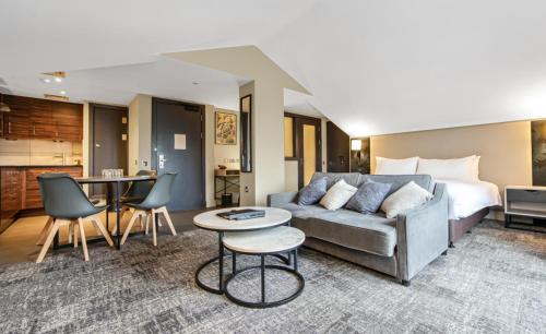 a living room with a couch and a bed at Doubletree By Hilton London Kensington in London