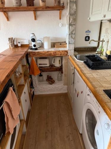 a small kitchen with a washer and dryer in it at Studio avec cheminée et jardin in Gréolières