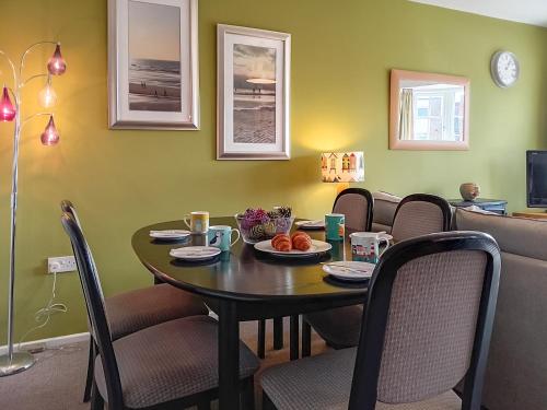 a dining room with a table and chairs at Dihangfa Wylau in Tywyn