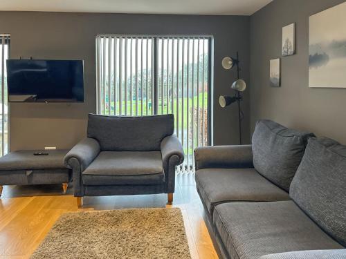 a living room with a couch and a chair and a tv at Bellstane Chalet - Ukc9440 in Glasgow
