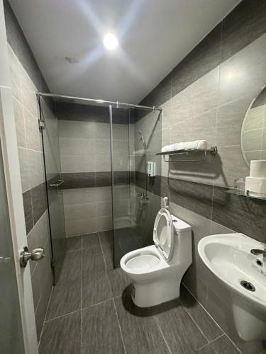 a bathroom with a shower and a toilet and a sink at Sông Kinh Hotel - Hồ Tràm in Xóm Trương Quít
