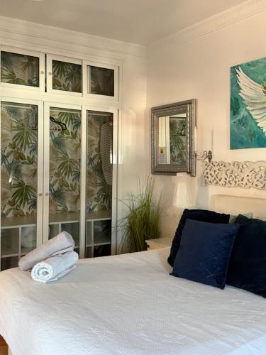 a bedroom with a white bed with blue pillows at Circus-Goretti House in Mairena del Aljarafe