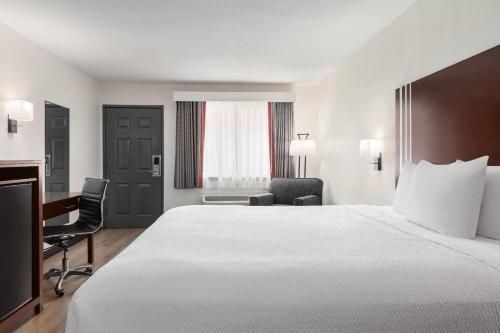 a hotel room with a large bed and a desk at Ramada by Wyndham San Antonio Near SeaWorld - Lackland AFB in San Antonio