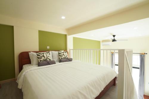 a bedroom with a large bed with green walls at Nagomi Studio Nyanyi in Cemagi