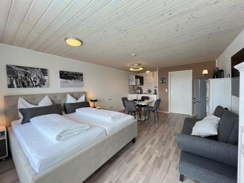 a bedroom with a large white bed and a table at Allgäuauszeit mit Bergblick - Sauna - Balkon in Scheidegg