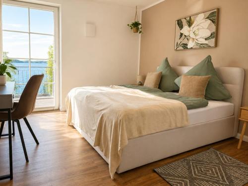 a bedroom with a bed and a table and a window at Bei Plön mit Seeblick und großem Balkon in Dersau