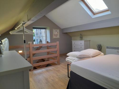 a attic bedroom with two beds and a ladder at Le Cerf volant in Libin