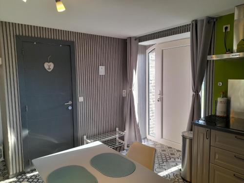 a room with a table and a blue door and a table and chairs at Le Cerf volant in Libin
