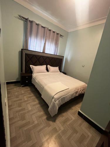 a bedroom with a large bed with a wooden floor at Soana in Fort Portal