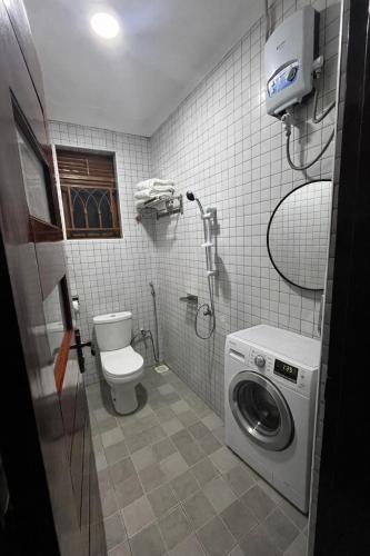 a bathroom with a toilet and a washing machine at Soana in Fort Portal