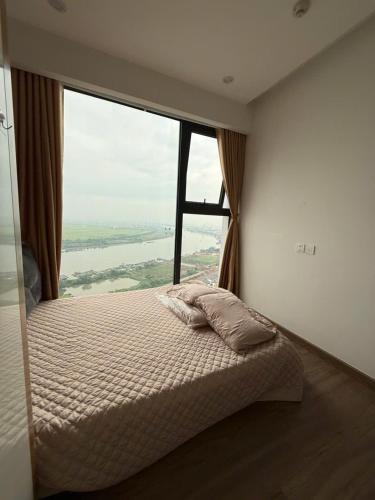 a bed in a room with a large window at Maison Joie Ecopark Lighthouse Ecorivers Hải Dương in Hải Dương