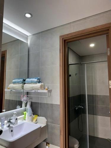 a bathroom with a sink and a shower with a mirror at Maison Joie Ecopark Lighthouse Ecorivers Hải Dương in Hải Dương