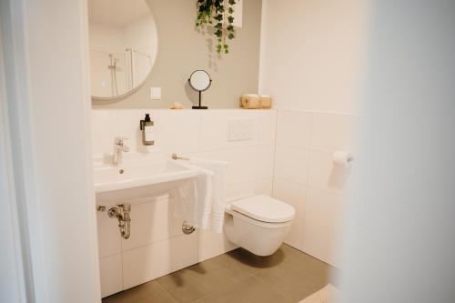 a white bathroom with a toilet and a sink at Bei Plön mit Seeblick und großem Balkon in Dersau