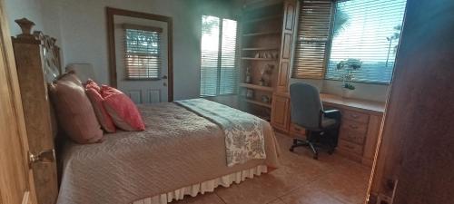 a bedroom with a bed and a desk and a chair at Casa Lagunita in Ensenada