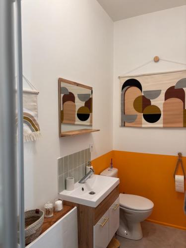 a bathroom with a toilet and a sink at Vénusté, Suite romantique in Périgueux
