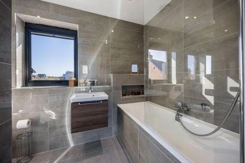 a bathroom with a tub and a sink and a window at Cosy Cottage in Dorchester