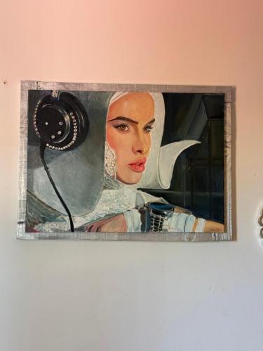 a painting of a woman with a camera on a wall at Evens-Goretti House in Mairena del Aljarafe