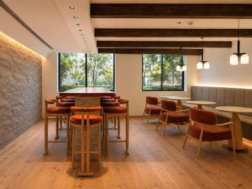 a restaurant with tables and chairs and windows at KIORI Collection Gokomachi in Kyoto