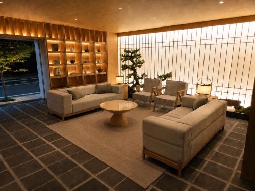 a living room with couches and chairs and a table at KIORI Collection Gokomachi in Kyoto