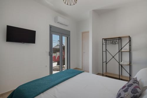a bedroom with a bed and a tv on the wall at Marilia Studios in Livadakia