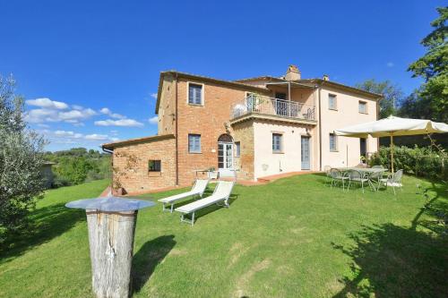a house with chairs and tables in the yard at Fontesecca - Happy Rentals in Città della Pieve