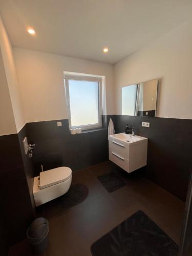 a bathroom with a white toilet and a sink at Modern new-build apartment in Groß-Gerau