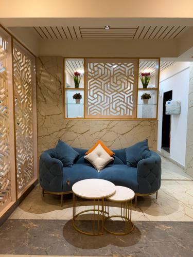 a living room with a blue couch and two tables at Aurelia INN - JP Nagar in Bangalore