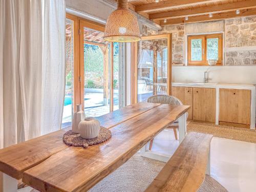 a dining room with a wooden table and a kitchen at Dolce Terra in Stari Grad