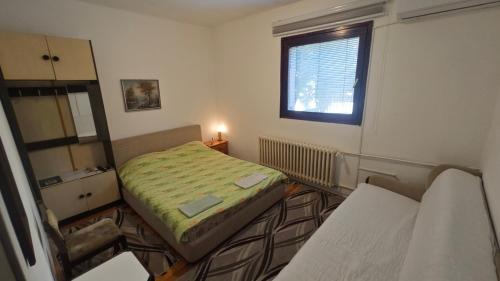 a small bedroom with a bed and a window at Prenoćište Dika in Višegrad