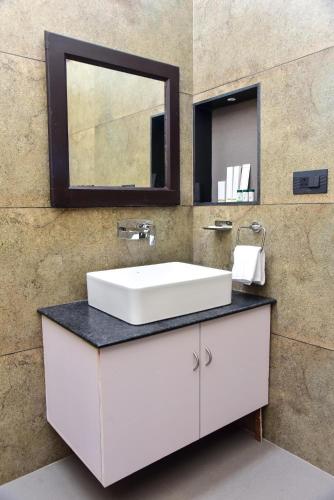 a bathroom with a white sink and a mirror at The Pentouz Hillside Chikmagalur in Chikmagalūr