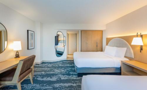 a hotel room with a bed and a desk at Embassy Suites by Hilton Minneapolis Bloomington Edina in Bloomington